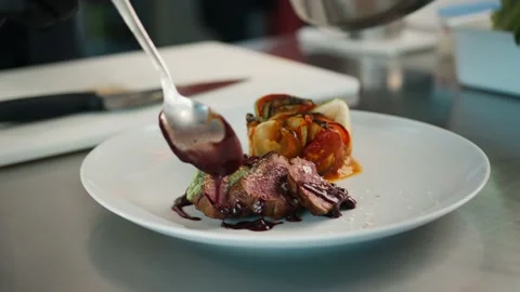 The chef pours sauce over the filet mignon. Serving food in a restaurant. Stock Footage 201926269