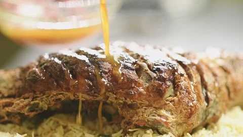 The chef pours sauce over the roasted leg of lamb. Stock Footage 165467022