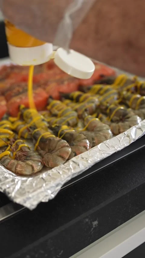 The chef pours the sauce over the shrimp and fish on a tray Stock Footage 278714493