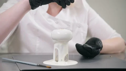 Chef pours small beads on delicious cake with white cream Stock Footage 139487173