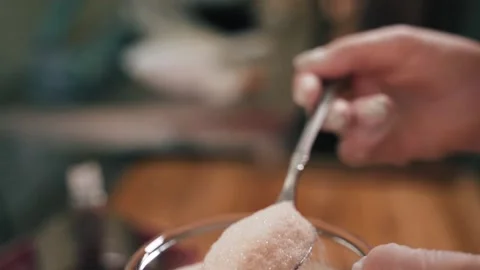 Chef pours sugar from spoon into cup Stock Footage 155203099