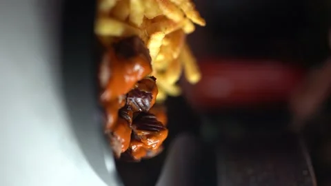Chef pours tomato paste sauce over french fries and sausage Stock Footage 181027039