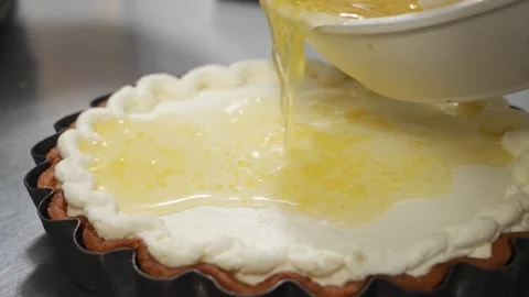 Chef Pours Vibrant Lemon Curd Over Cream Filling for Homemade Dessert Pie Stock Footage 337751193