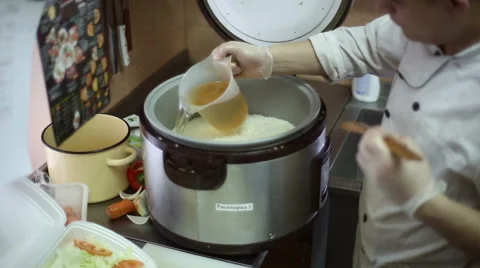 The chef pours vinegar mixture into the rice Stock Footage 59699159