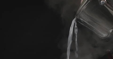 Chef pours water from the pan with pasta over black background. Steam or vapor Stock Footage 250220134