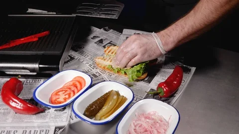 A chef prepared mackerel burger with fresh lettuce, tomato, onion and pepper Stock Footage 128292562