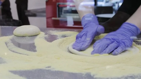 The chef prepares the basis for pizza from fresh dough in the cafe 動画素材 119312338