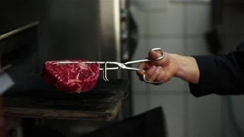 Chef prepares beef steak slow motion HD video: puts meat in grill charcoal oven Stock Footage 70003855