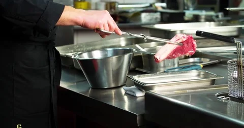 Chef prepares bone steak 4k video: puts meat grill charcoal oven. BBQ restaurant Stock Footage 70005734