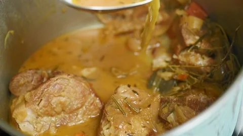 The chef prepares braised pork shoulder in the pot. Stock Footage 244387074