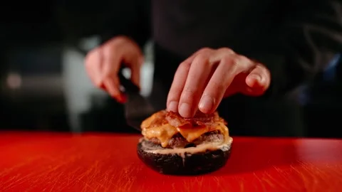 The chef prepares a burger. Beef, pork, cucumber, sauce and onion. Stock Footage 158171567