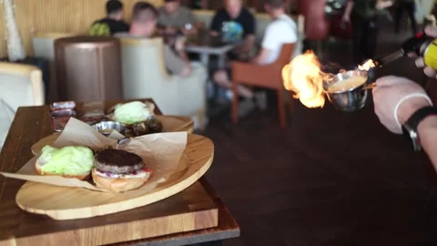 A chef prepares a burger in the kitchen and toasts buns on the grill Video stock 338158216