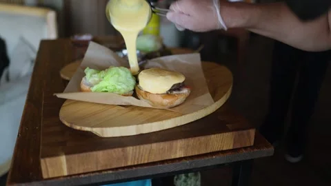 A chef prepares a burger in the kitchen and toasts buns on the grill Video stock 338158234
