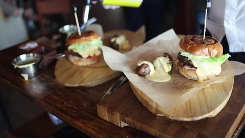 A chef prepares a burger in the kitchen and toasts buns on the grill Video stock 338158253