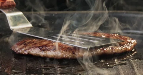 Chef prepares burger patty on the grill. Hamburger or cheeseburger preparation Stock Footage 293871851