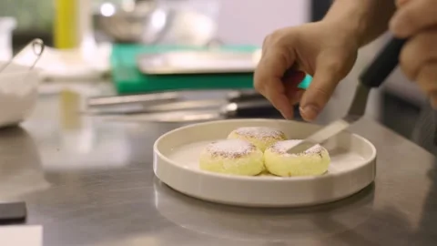 The chef prepares cheese pancakes in the kitchen of the cafe. Stock Footage 277131663