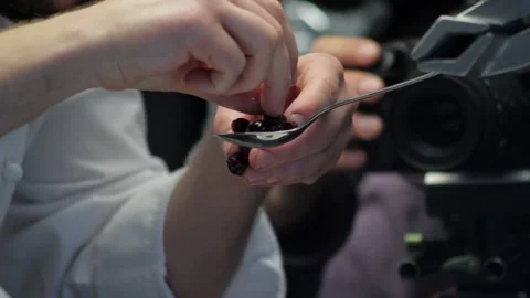 Chef prepares cherries in a spoon for filming Stock Footage 238002214