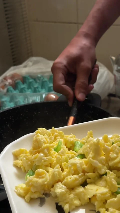 A chef prepares creamy scrambled eggs on toasted bread with fresh salad, close Stock-Footage 342574673