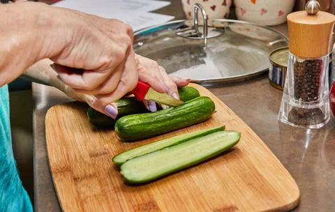 Chef prepares the cucumbers for stuffing and baking Stock Photos
