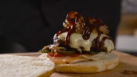 The chef prepares a delicious burger on a serving plate close-up. Cheeseburger Stock Footage 248161531