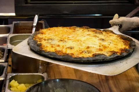 Chef prepares delicious pizzas on the kitchen Stock Photos
