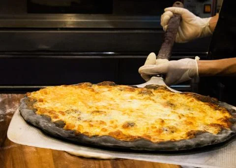 Chef prepares delicious pizzas on the kitchen Stock Photos