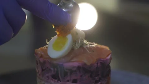Chef prepares diet lunch in kitchen. Puts slices caviar on plate salad Video stock 303554759