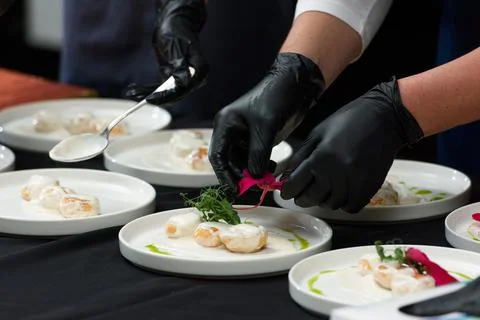 The chef prepares a dish of fish balls in a creamy sauce Stock Photos