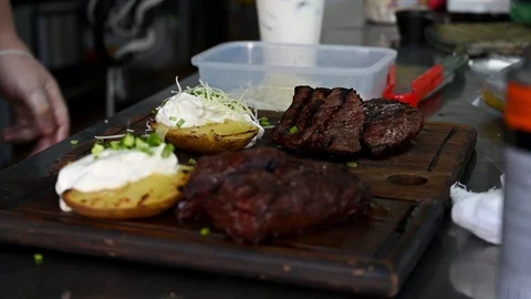 The chef prepares dishes with steaks for serving Stock Footage 125889864