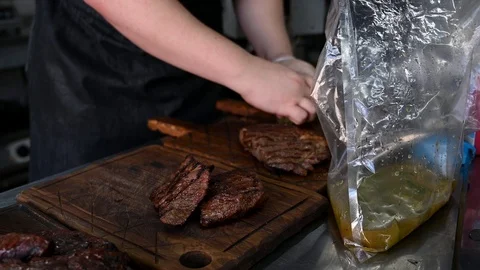 The chef prepares dishes with steaks for serving Stock Footage 125889867