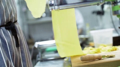 Chef prepares dough for pasta using pasta machine. In the background interior of Stock Footage 74718603