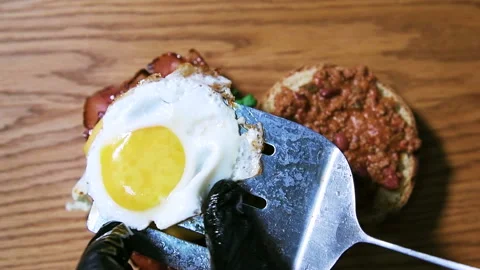 The chef prepares an egg Burger with bacon and cheese. Stock Footage 101751315