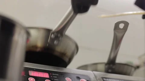 The chef prepares food in black gloves in a frying pan, in the kitchen in a Stock Footage