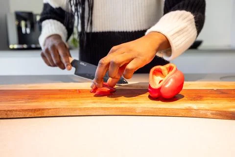 Chef prepares fresh red bell pepper, cutting carefully in a modern kitchen for a Stock Photos