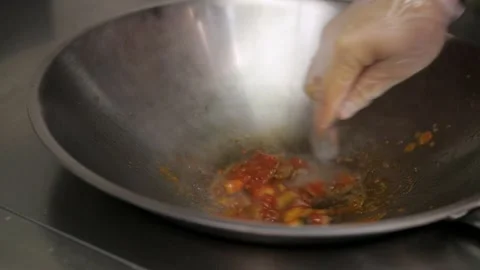 A chef prepares fried pieces of meat, peppers in a huge wok in a restaurant - a Stock-Footage 147834399