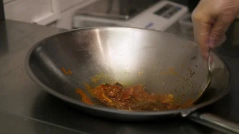 A chef prepares fried pieces of meat, peppers in a huge wok in a restaurant - a Stock-Footage 147901069