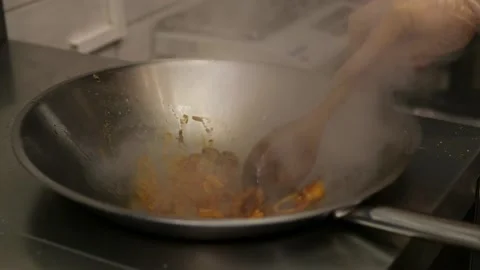A chef prepares fried pieces of meat, peppers in a huge wok in a restaurant - a 스톡 동영상 148005171