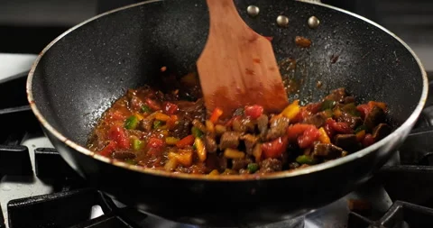 Chef prepares with meat and vegetables on a stove, stir meat colorful bell Stock Footage 290290233