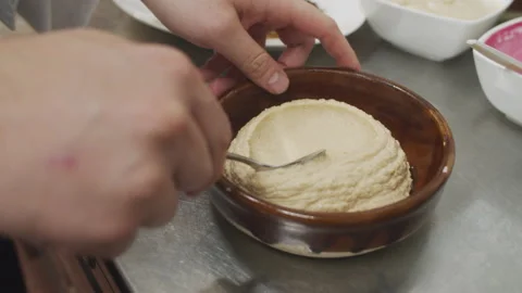 Chef prepares mediterranean hummus starter dish. Forming hummus with spoon Stock Footage 150586548