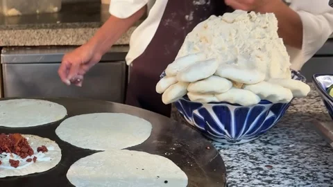 A chef prepares Mexican corn tortillas from a mound of dough in a blue-patterned Stock Footage 304329065