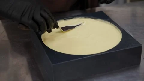 The chef prepares a mousse cake, pours pistachio mousse into a silicone mold. Video stock 270062448