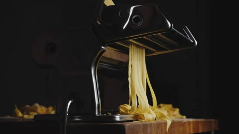 A chef prepares a pasta dish and makes his own tagliatelle in a machine Stock Footage 168880068
