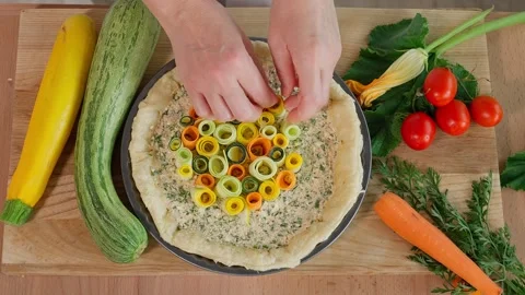 The chef prepares a pie with multi-colored zucchini and carrots, a Tuscan pie Stock Footage 264141632