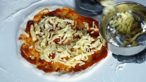 Chef prepares pizza topped with cheese Stock Footage 196062736