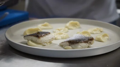 Chef prepares plate with slices of fish fillet on plate Stock Footage 117376985