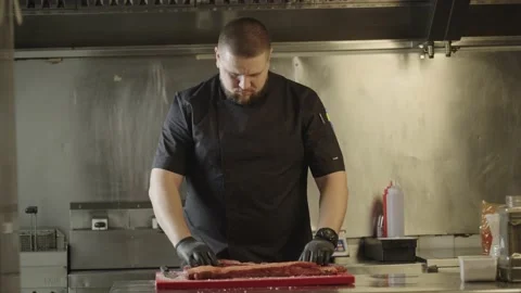The chef prepares raw meat for grilling. Chef salting pepper marinating ribs Stock Footage 235673926