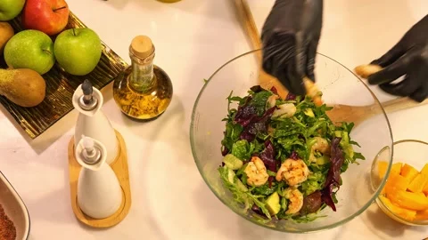 Chef prepares salad with rocket avocado and shrimp. Ingredients combined for Stock Footage 271233237