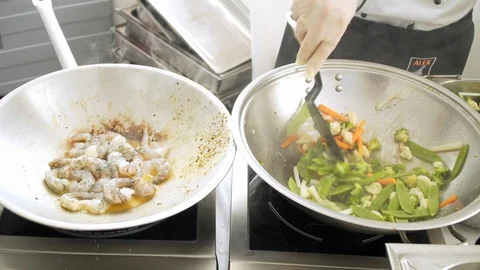 Chef prepares shrimp in a wok Stock Footage 115900107
