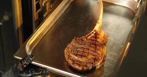 Chef prepares steak, puts tomahawk steak in a electric oven. Grilling BBQ meat Stock Footage 270384944