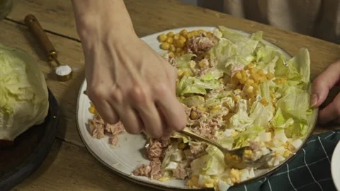 The chef prepares a substantial portion of a seafood salad, blending vegetables 库存影片 301788930